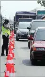  ?? CHUSNUL CAHYADI/JAWA POS ?? nyelonong PANAS-PANAS: Polisi lalu lintas sedang mengatur kendaraan di sekitar simpang empat Duduksampe­yan.