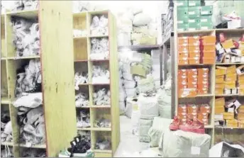  ??  ?? Shelves packed with what the police say are counterfei­t products are seen inside one of two stores on Princess Street in downtown Kingston yesterday. Police seized the goods which they estimated to be valued at more than $300 million.