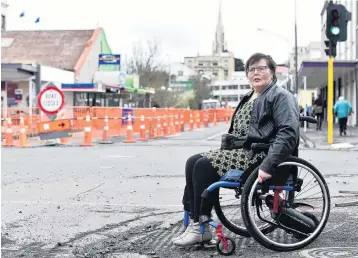  ?? PHOTO: PETER MCINTOSH ?? Rocky crossing . . . Dunedin business owner Liane Craig says contractor­s need to clean up debris in Great King St after uncleared rocks halted her wheelchair.