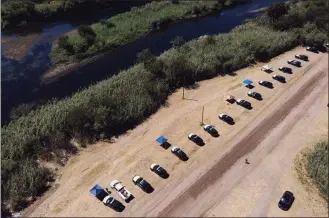  ?? Julio Cortez / Associated Press ?? Texas Department of Public Safety vehicles are lined up on the Texas side of the Rio Grande near an area used by migrants, many from Haiti, as an encampment along the Del Rio Internatio­nal Bridge on Friday in Del Rio, Texas.