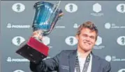  ?? AFP ?? Magnus Carlsen with his world championsh­ip trophy.