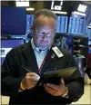  ?? (AP PHOTO/RICHARD DREW, FILE) ?? Trader Robert Arciero works on the floor of the New York Stock Exchange, Tuesday, Aug. 10, 2021. Higher inflation hasn’t dented Corporate America’s profit bonanza — so far.