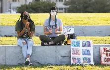  ?? Amy Osborne / Special to The Chronicle ?? Kaylyn Goode ( left) and Amy Prindle applaud a speaker at a Yes on Prop 16 rally at Oakland’s Lake Merritt on Friday.