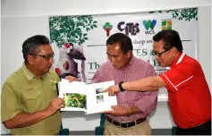  ??  ?? (From right) Lee, Len Talif and Zolkipli share a light moment as they browse a book, which was presented to Len Talif by Zolkipli earlier.