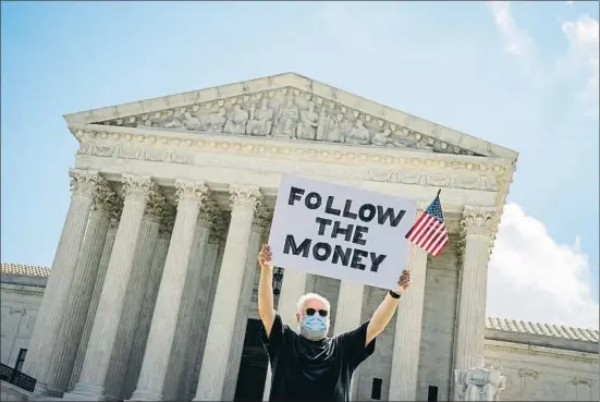  ?? SARAH SILBIGER / BLOOMBERG L.P. LIMITED PARTNERSHI­P ?? Un manifestan­te –el cartel dice: “Seguid el dinero”–, ayer delante de la sede del Tribunal Supremo