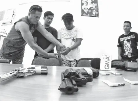  ??  ?? Petes Carlth Cabras and Cedrick Precillas are presented to the media after their arrest in Barangay Sta. Cruz for bringing a gun and a gun replica.