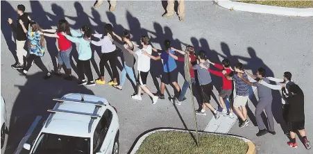  ?? AP PHOTOS ?? BRAVE: Aaron Feis, top right, and Chris Hixon, top left, were both killed Wednesday after a shooter opened fire on the campus, above. Showing no hesitation, they aided in saving students’ lives.