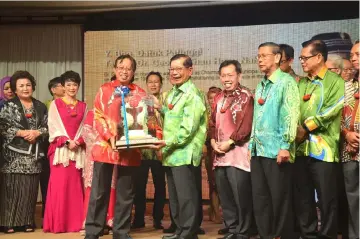  ??  ?? Abang Johari (left) presents the special award to Dr Chan. Also seen are Dr Sim (behind Dr Chan) and others.