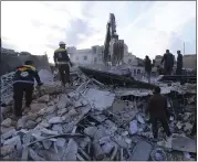  ?? GHAITH ALSAYED – THE ASSOCIATED PRESS ?? Emergency services workers look for survivors after an airstrikes in the city of Idlib, Syria, on Wednesday. Syrian government warplanes struck a market and an industrial area in the last territory in the hands of rebel groups in the country’s northwest, killing at least 15 people, opposition activists said.