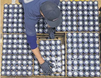  ?? KARL MERTON FERRON/BALTIMORE SUN ?? Wayne Hill stacks six-packs onto a waiting forklift at DuClaw Brewing Co. on Tuesday.