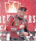  ?? PAUL SANCYA/AP ?? Kevin Harvick celebrates after winning the Cup Series race at Michigan Internatio­nal Speedway.