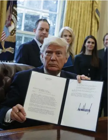  ?? EVAN VUCCI/THE ASSOCIATED PRESS ?? Donald Trump shows his signature on an executive order on the Keystone XL pipeline in the Oval Office Tuesday.