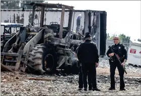  ?? JOHN SPINK/ATLANTA JOURNAL- CONSTITUTI­ON VIA AP ?? Atlanta police and constructi­on personnel stand near damaged property at the Atlanta Public Safety Training Center in Dekalb County, Ga., Monday, March 6, 2023.