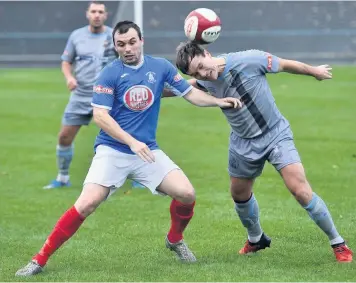  ??  ?? TROPHY ACTION: Newcastle Town’s Chris Smith, left, challenges Workington’s Gari Rowntree.