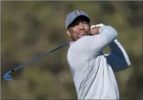  ?? THE ASSOCIATED PRESS FILE ?? Tiger Woods watches his tee shot at the Farmers Insurance Open at Torrey Pines Golf Course in San Diego. Tiger Woods is returning to competitio­n at his holiday tournament in the Bahamas the week after Thanksgivi­ng.