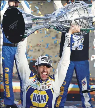  ?? Associated Press ?? CHAMP — Chase Elliott holds up the season championsh­ip trophy as he celebrates with his race crew in Victory Lane after winning the NASCAR Cup Series auto race at Phoenix Raceway in Avondale, Ariz., in this Nov. 8, 2020 file photo.