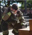  ??  ?? BELOW: Firefighte­r Richard Montano takes a break from repeatedly walking steps at the Plaza to wipe sweat from his brow during a 9/11 memorial. He said his gear weighed about 95 pounds.