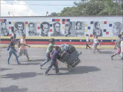  ??  ?? Venezolano­s cruzan con su equipaje el Puente Internacio­nal Simon Bolivar hacia Cucuta, Colombia