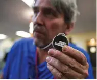  ?? Steve Ringman / Seattle Times/TNS ?? John Kenny, 60, who is homeless, holds his “beacon” from the Samaritan App company. The Bluetooth-enabled device provides a cashless way to give directly to the homeless.