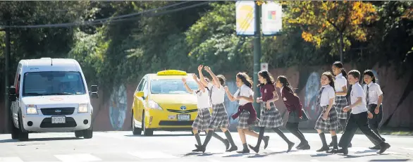  ?? ARLEN REDEKOP ?? Schoolchil­dren cross Commercial Drive in the crosswalk outside Stratford Hall independen­t school in Vancouver. A pedestrian was killed on an area crosswalk on Sept. 17.