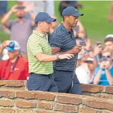  ?? ?? Rory McIlroy walks with Tiger Woods to the 13th hole.