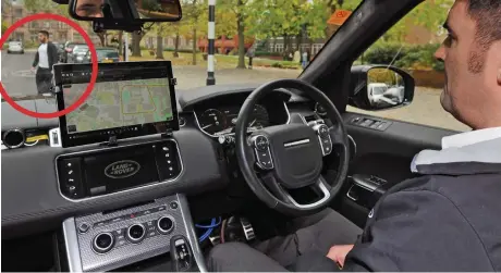  ??  ?? Hands-off: A pedestrian (circled) crosses in front of the self-driving car – with a ‘driver’ supervisin­g but not touching the wheel – in Milton Keynes