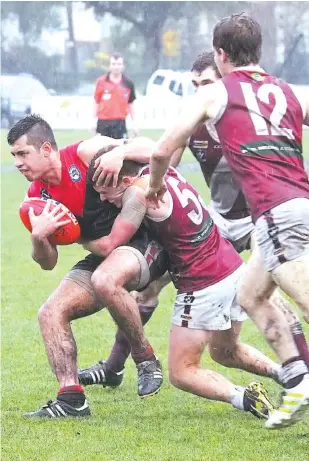  ??  ?? Warragul on-baller Nathan Paredes was in the thick of the ground level action against Traralgon on Saturday but managed to keep his arms free when vigorously tackled by Cory Stockdale.