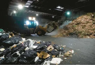  ?? JEFF CHIU/AP ?? Organic material is picked up for loading onto a truck Oct. 27 at a GreenWaste Renewable Energy Digestion facility in California.