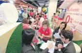  ?? PHRAKRIT JUNTAWONG ?? A saleswoman for a housing developer provides project details to a customer at a housing fair. GH Bank offers lowrate mortgages for low-income earners.