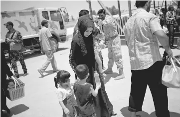  ??  ?? An Iraqi woman and her children arrive at a processing centre before being transferre­d to refugee camps, in western Mosul, Iraq. — Reuters photo