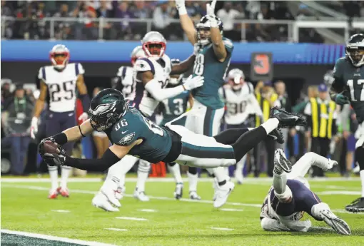  ?? Elsa / Getty Images ?? Tight end Zach Ertz, who had seven receptions, dives across the goal line for a touchdown that put the Eagles ahead for good in Super Bowl LII.