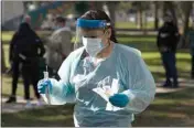  ?? JAE C. HONG / AP ?? Medical assistant Leslie Powers carries swab samples collected from people to process them on-site Thursday at a COVID-19 testing site in Long Beach.