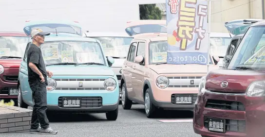  ?? PHOTOS BY REUTERS ?? Yorie Miho, 80, takes a look at minicars at a minicar dealership in Yamato, Kanagawa prefecture.