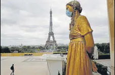  ?? AP/FILE ?? A mask is put on a statue next to Trocadero Square close to the Eiffel Tower in Paris.