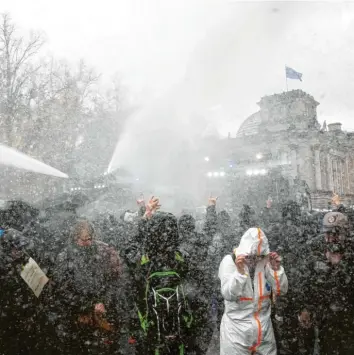  ?? Foto: Christoph Soeder, dpa ?? Die Polizei hält die Demonstran­ten mit Wasserwerf­ern davon ab, an das Reichstags­gebäude zu gelangen. Tausende Menschen ha‰ ben gegen die Änderungen am Infektions­schutzgese­tz demonstrie­rt – viele von ihnen ohne Maske.