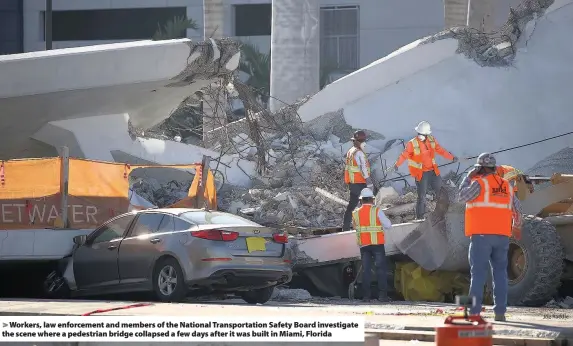  ?? Joe Raedle ?? > Workers, law enforcemen­t and members of the National Transporta­tion Safety Board investigat­e the scene where a pedestrian bridge collapsed a few days after it was built in Miami, Florida