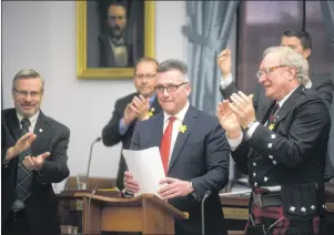  ?? NATHAN ROCHFORD/THE CANADIAN PRESS ?? P.E.I. Premier Wade MacLauchla­n applauds alongside Liberal Finance Minister Heath MacDonald during the release of the provincial budget in Charlottet­own on Friday.