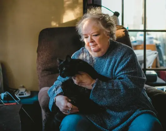  ?? JAMIE KELTER DAVIS/THE NEW YORK TIMES 2022 ?? Lynne Ingersoll, 77, holds her cat Jesse at her home in Blue Island, Illinois. Ingersoll is considered “kinless”: without a partner, offspring or siblings.