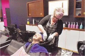  ?? MICHAELA HELEAN ?? The Hype Hair Studio Owner Kristine Templeton conditions employees’ recently colored hair.
