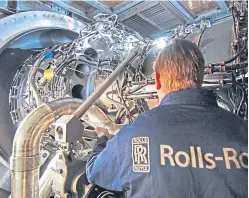  ??  ?? A Rolls-Royce technician works on an aero engine.