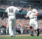  ?? NHAT V. MEYER — STAFF PHOTOGRAPH­ER ?? Hunter Pence, right, high-fives Austin Jackson after Pence scored on Buster Posey’s tying single in the eighth inning.