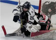  ?? JIM MICHAUD / BOSTON HERALD ?? COMING THROUGH: Framingham's Thomas Duane falls on Reading goalie Dylan Emery moments before scoring his second goal of the game in the second period.