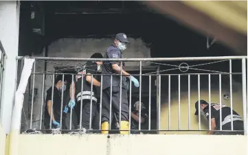  ??  ?? Police personnel from the Bukit Aman Forensics Unit conducting their investigat­ions at the school. — Bernama photo