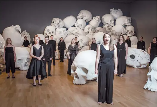  ?? EUGENE HYLAND ?? Canto entre calaveras. El grupo The Polyphonic Voices canta “Amazing Grace” a la escultura “Mass”, de Ron Mueck.