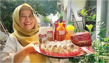  ?? HANAA SEPTIANA/JAWA POS ?? SEJAK 2009: Sri Wahyuni menunjukka­n beberapa jenis produksi rumahan yang dibikinnya.