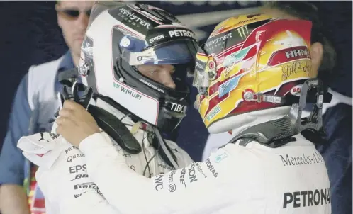  ??  ?? 0 Britain’s Lewis Hamilton, right, congratula­tes his Mercedes team-mate Valtteri Bottas on his victory in the Russian Grand Prix.