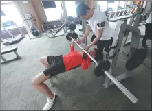  ?? WEI XIAOHAO / CHINA DAILY ?? Ji Lijia (left) does weight training exercises with the help of a teammate on March 20.