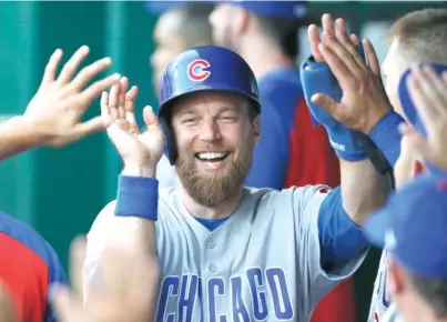  ?? AP ?? Ben Zobrist, who left in the fifth inning with a left hip injury, celebrates with teammates after scoring in the first inning.