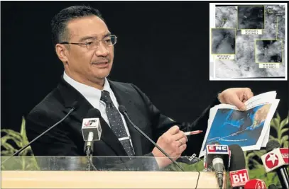  ?? Pictures: REUTERS ?? LOOKING FOR ANSWERS: Malaysian Defence Minister and Acting Transport Minister Hishammudd­in Hussein shows pictures of possible debris from the missing Malaysia Airlines flight MH370 in Kuala Lumpur. INSET: A satellite image of the location of objects in...