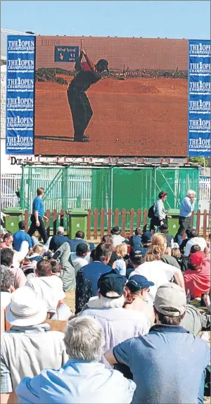  ?? Picture: Allsport. ?? Spectators watch Tiger Woods in action on a giant screen during the final round of the Open at the Old Course, St Andrews, in 2000.